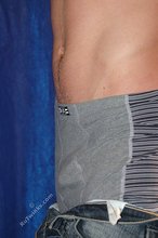 Muscular teen boy taking his jeans off on camera