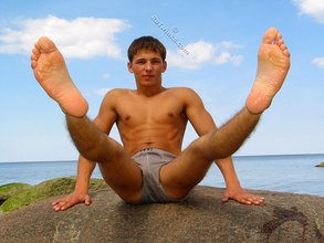 Muscular dark-haired guy strokes his cock outdoors