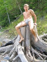 Muscular dark-haired guy strokes his cock outdoors