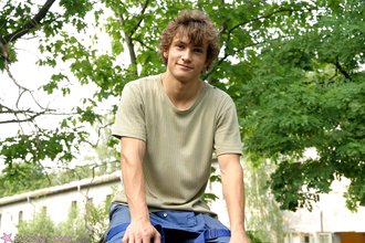 Curly-haired twink posing shamelessly outdoors