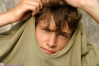 Curly-haired twink posing shamelessly outdoors