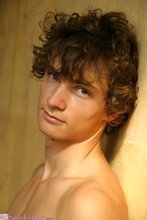 Curly-haired twink posing shamelessly outdoors
