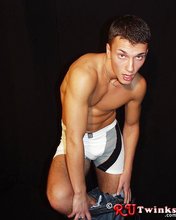 Tanned and muscular twink stripping in a very very dark room