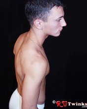Tanned and muscular twink stripping in a very very dark room