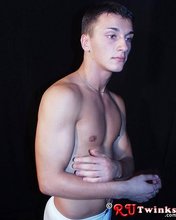 Tanned and muscular twink stripping in a very very dark room
