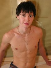 Dark-haired guy with muscles pulls down his pants ever so slightly