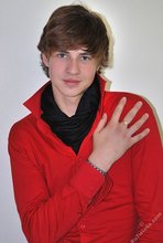 Long-haired twink in red slowly undressing in front of the cam