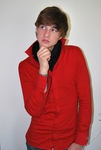 Long-haired twink in red slowly undressing in front of the cam