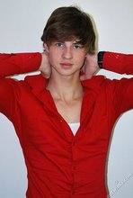 Long-haired twink in red slowly undressing in front of the cam