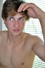 Dark-haired guy with a hairy cock posing by the window