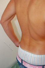 Tanned guy with a hot body showing his muscular back as well