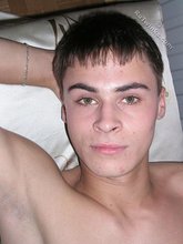 Brunette boy shyly sticking a finger in his mouth to mimic a BJ