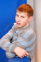 Blond-haired guy posing next to a lamp after fucking the wall