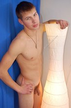 Blond-haired guy posing next to a lamp after fucking the wall