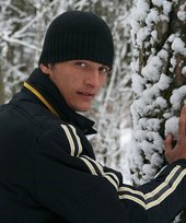 Beautiful young boy posing outdoors with trees