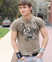 Athletic dude in oversized jeans is doing handstands outdoors