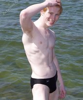 Redheaded twink posing in his sexy shades on a beach