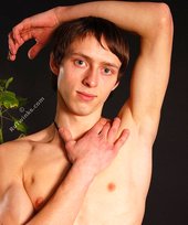 Beautiful-looking twink posing shirtless on a bed