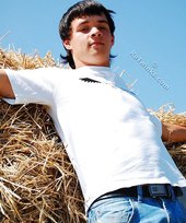 Dark-haired young twink posing in a haystack