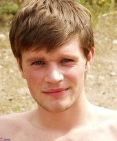 Sneakers-wearing twink posing seductively outdoors