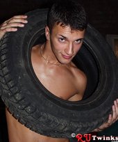 Dark-haired guy with a perfect body moving tires and looking hot